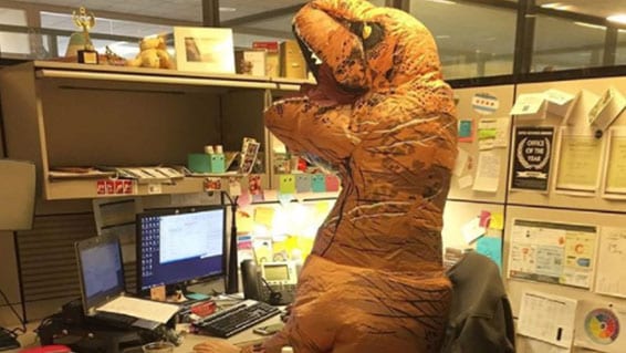 Inflatable dinosaur sitting at a desk in a Ketchum office