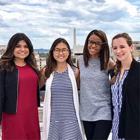 Four women outside posing