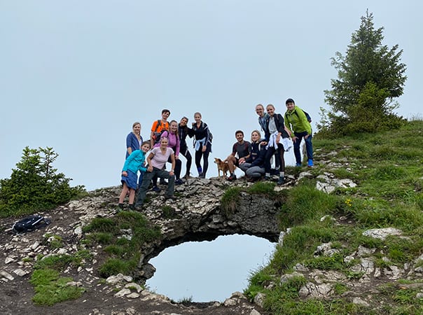 A group of female and male Ketchum Vienna colleagues with backpacks and a dog outside