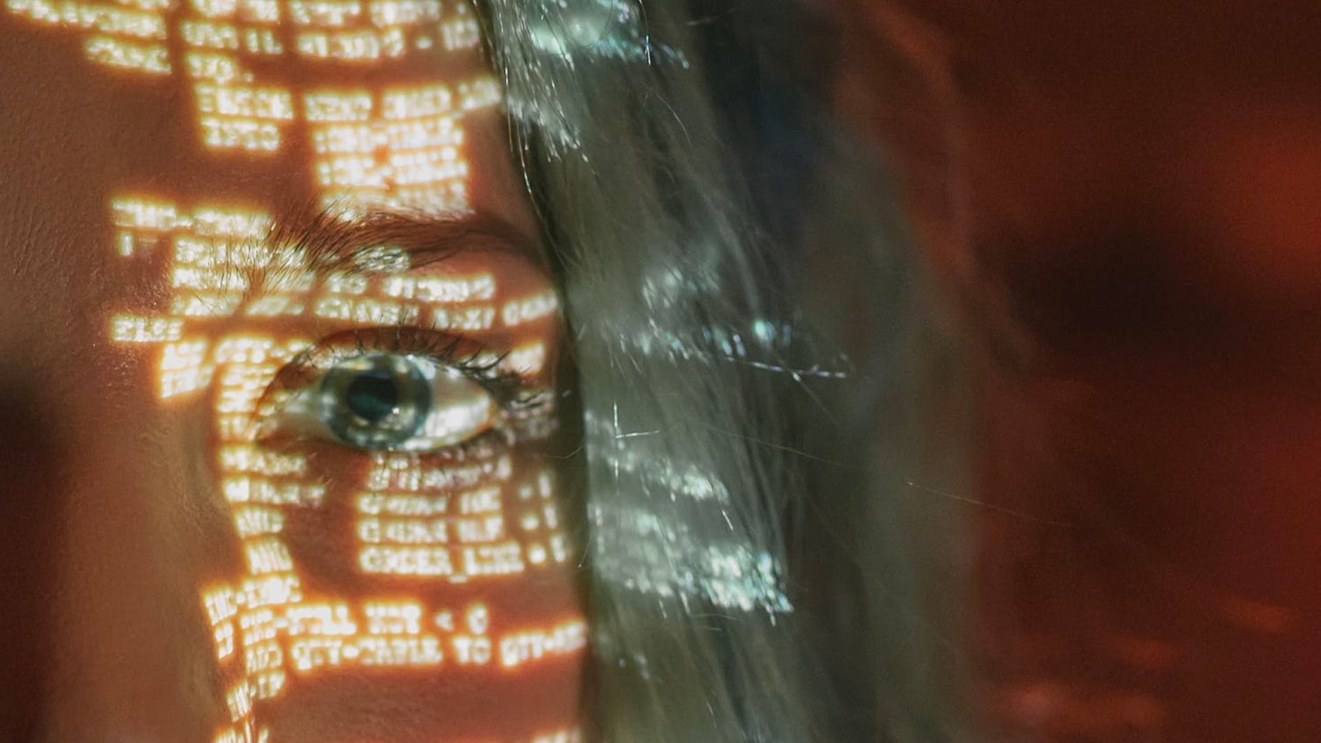 A Cybersecurity Strategy for Reputation and Business Continuity - close-up of woman's face with computer code projected onto it