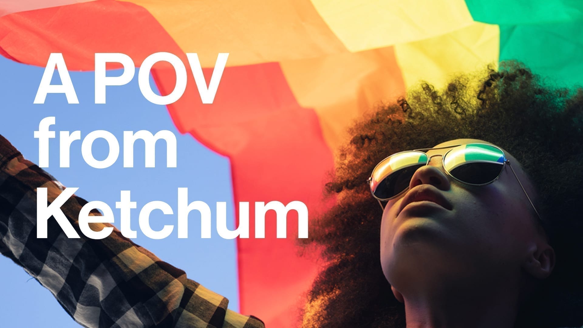 A POV from Ketchum - photo of Black woman holding pride flag over her head
